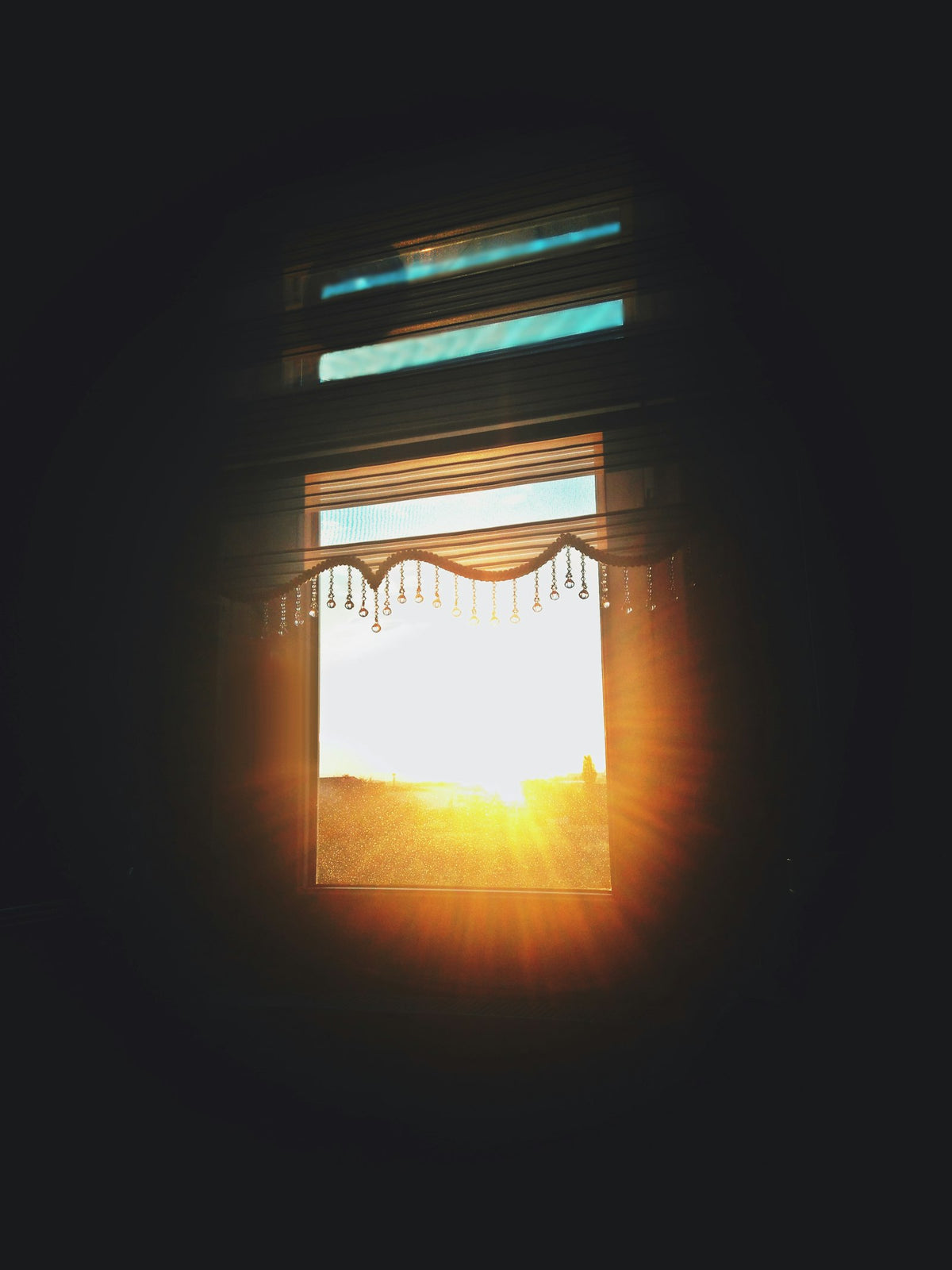 Warm sunlight streaming through window blinds, the natural source of vitamin D