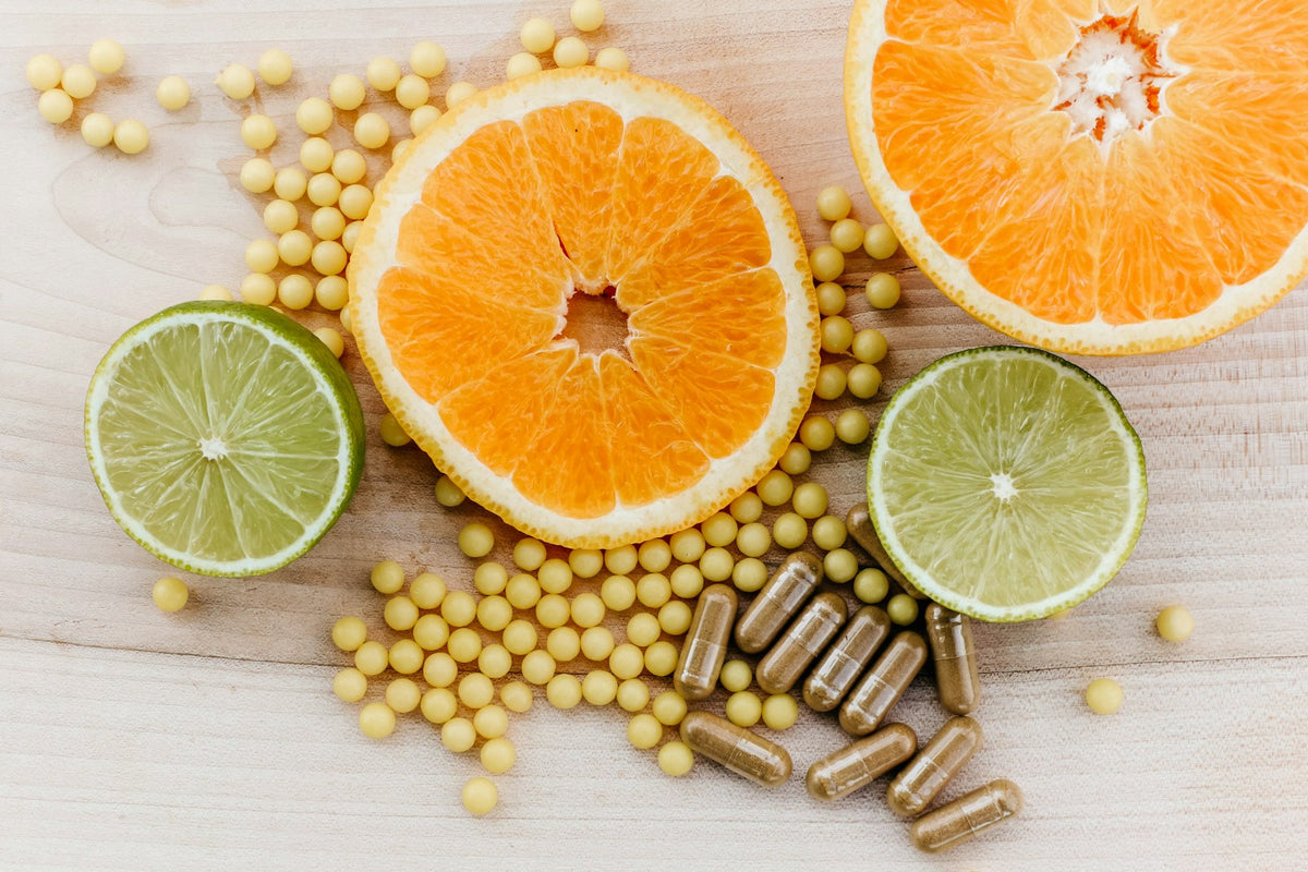 Oranges, peas and limes on a wooden table, showing nutrients working together in whole foods
