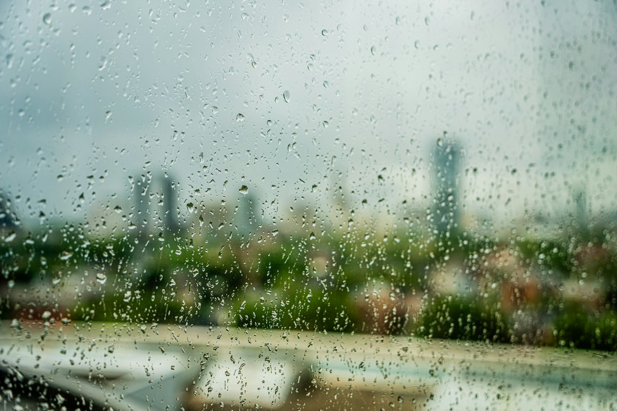 A view of a UK city street through a rain-covered window in winter