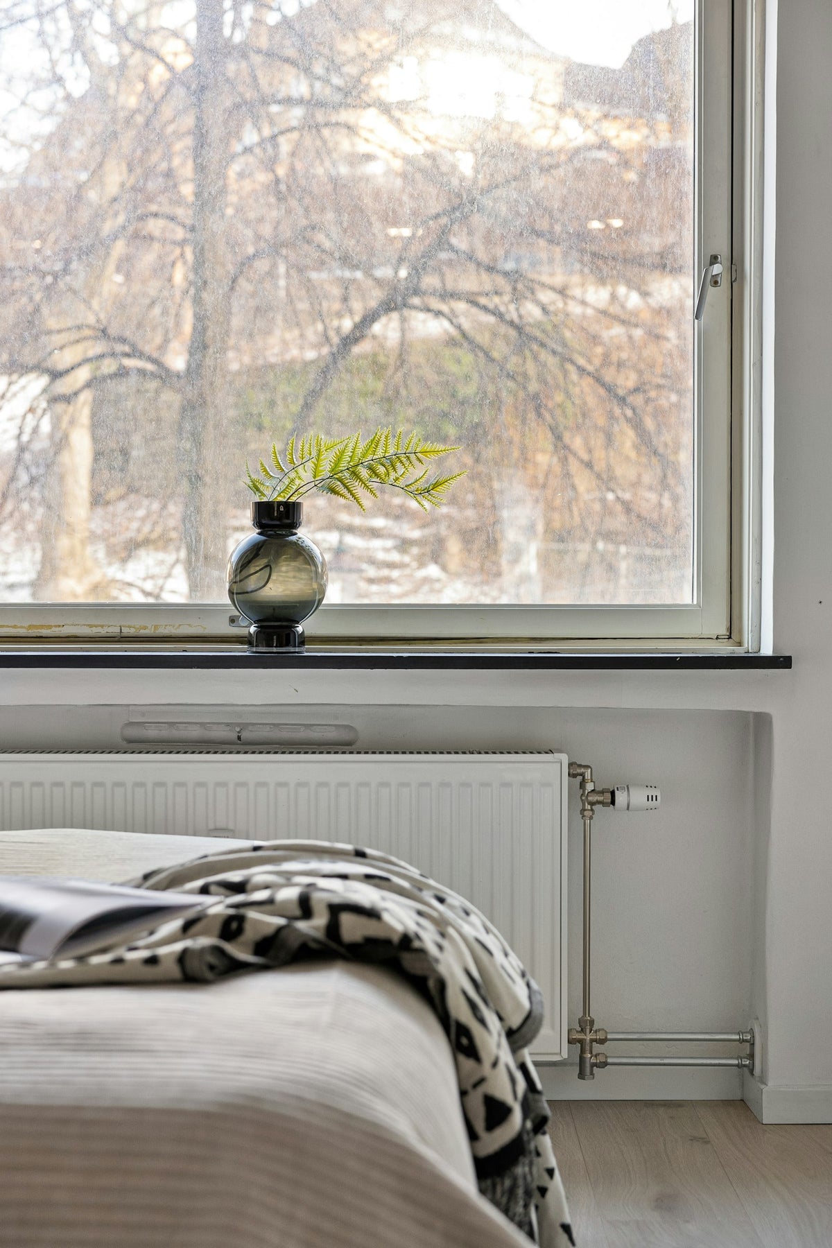 A dim bedroom with a window on a grey winter morning, illustrating winter tiredness